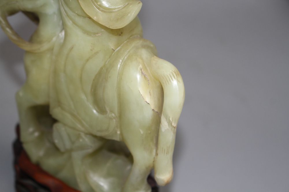 A pair of Chinese bowenite jade groups of a lady riding a horse, wood stands total height 26.5 and 27cm